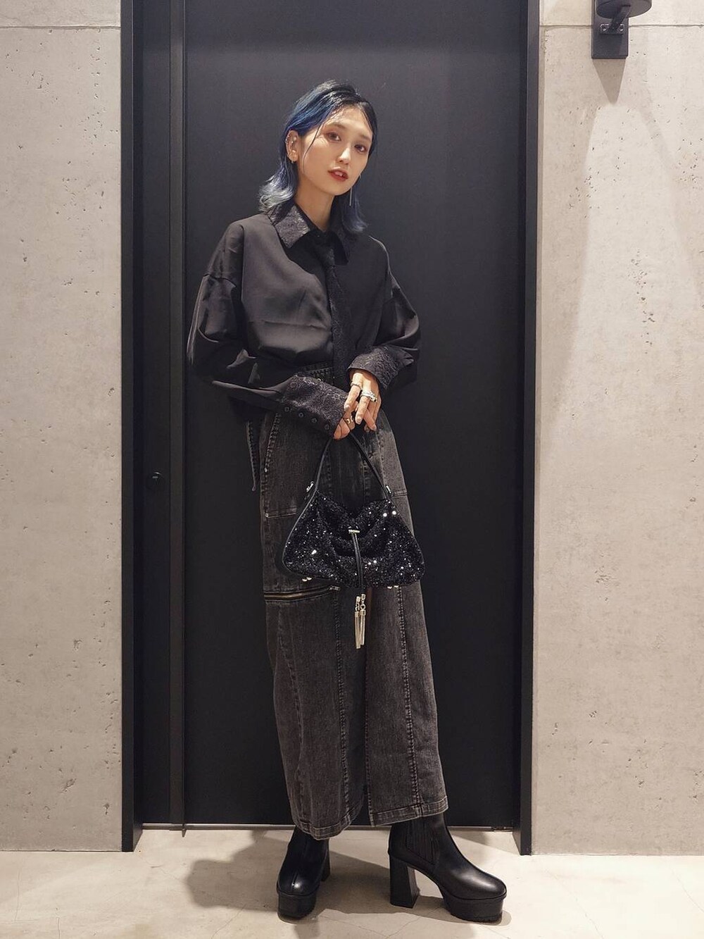 ブラック系のショルダーバッグ、ブラック系のシャツ/ブラウス、ブラック系のブーツを着用したレディースの夏コーディネートの2枚目の写真