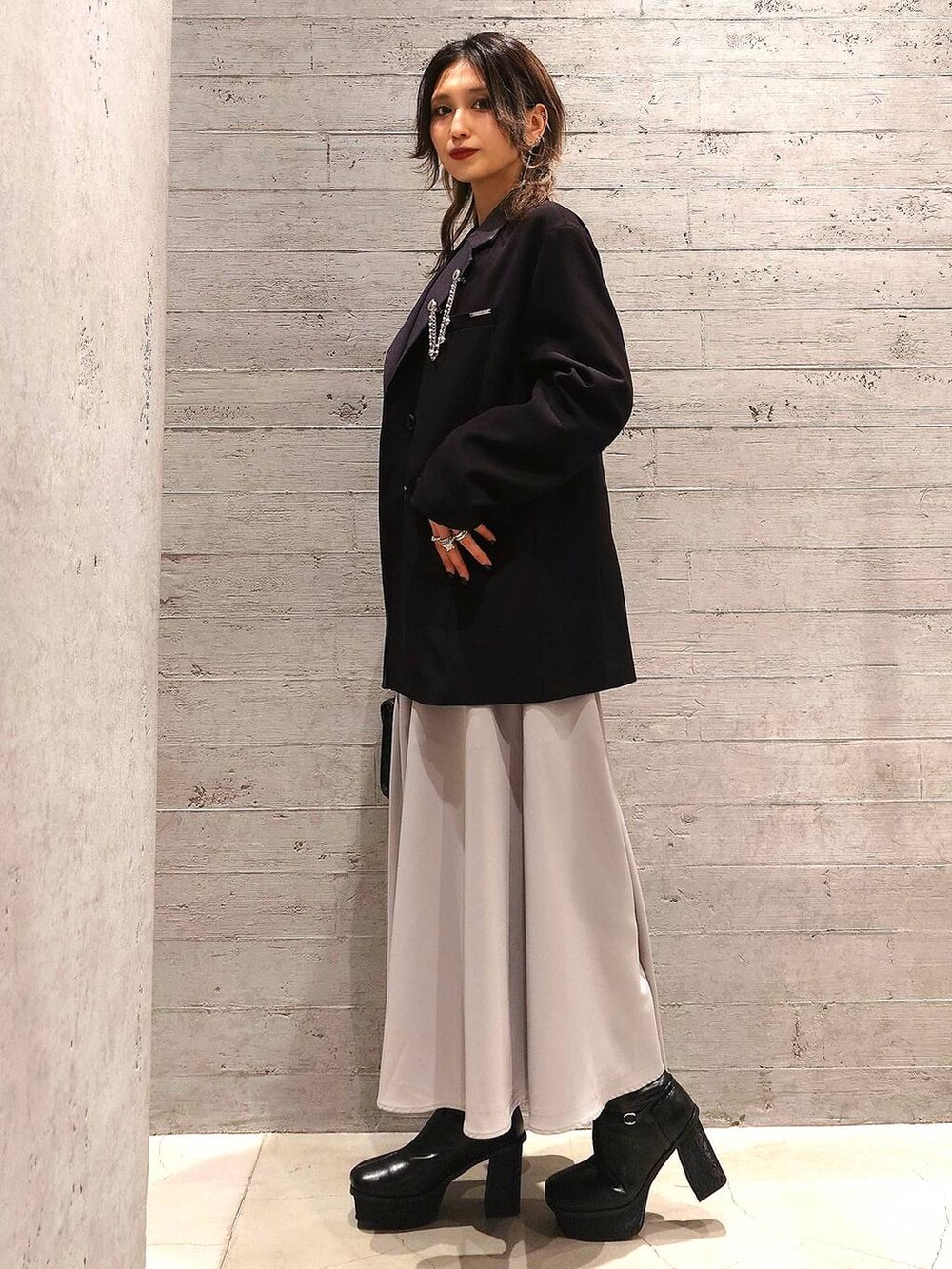 ブラック系のニット/セーター、ブラック系のショルダーバッグ、グレー系のスカートを着用したレディースの冬コーディネートの3枚目の写真