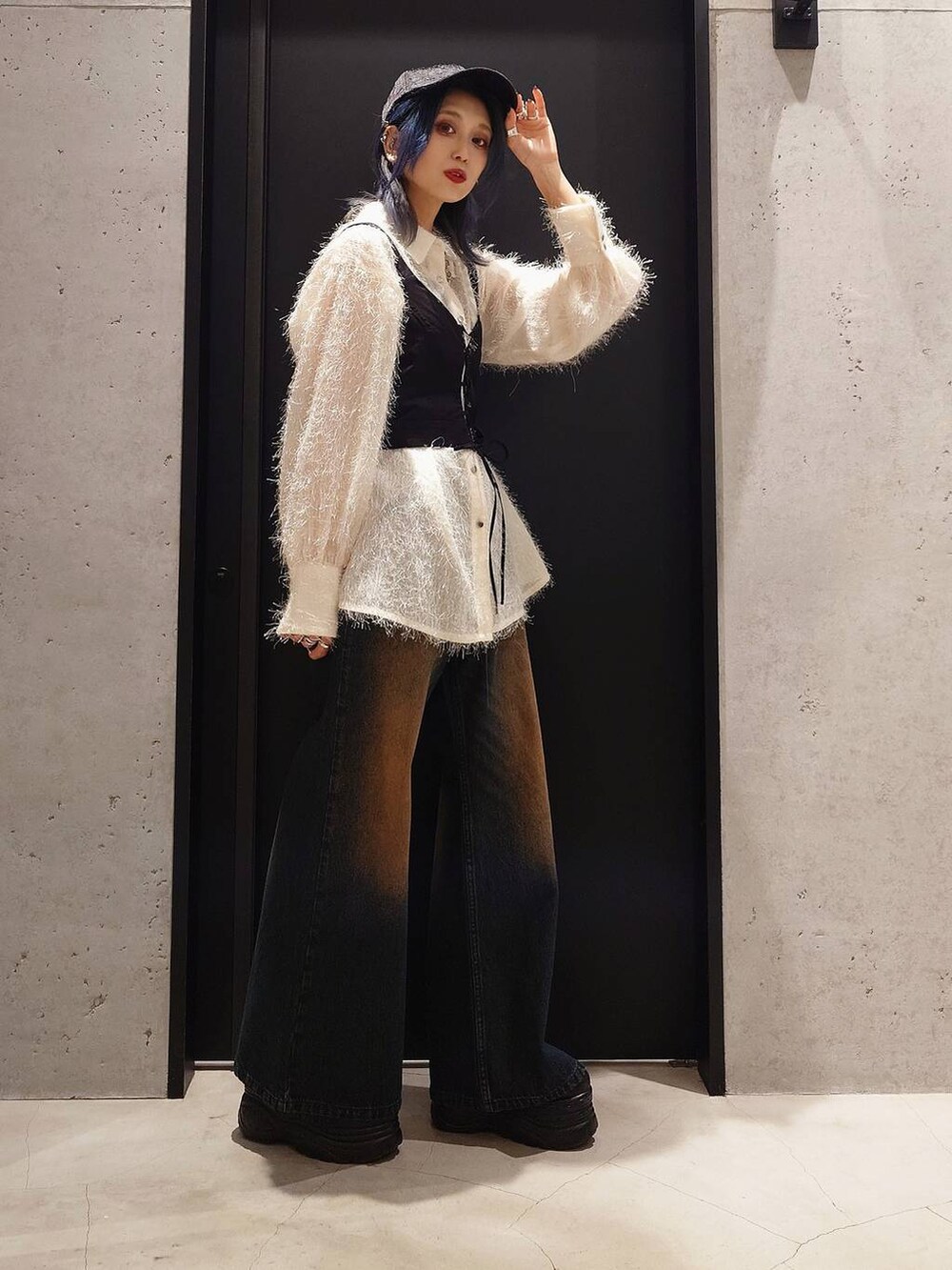 ブルー系のデニムパンツ、ホワイト系のシャツ/ブラウス、ブラック系のショルダーバッグを着用したレディースの冬コーディネートの2枚目の写真