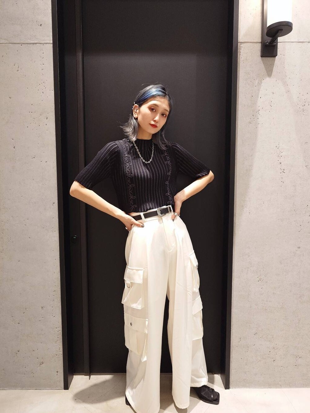 ブラック系のサンダル、ホワイト系のカーゴパンツ、ブラック系のニット/セーターを着用したレディースの春コーディネートの3枚目の写真