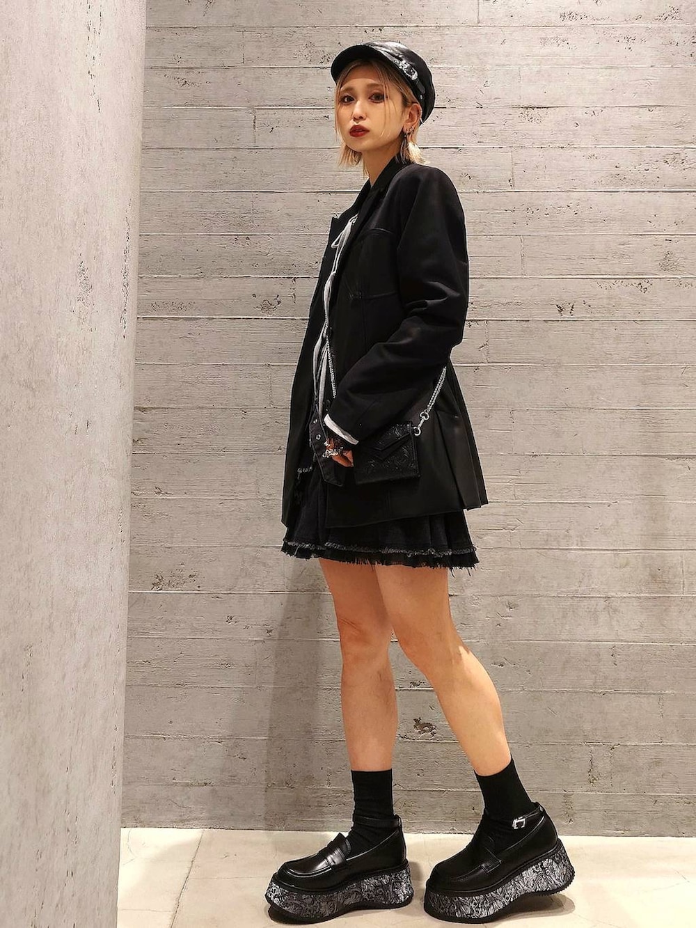 ブラック系のテーラードジャケット、ブラック系のスカート、グレー系のTシャツ/カットソーを着用したレディースの春コーディネートの2枚目の写真