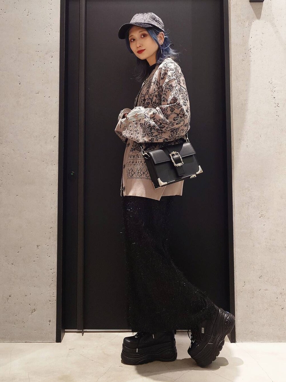 ブラック系のショルダーバッグ、ブラック系のスカート、グレー系のカーディガン/ボレロを着用したレディースの冬コーディネートの2枚目の写真