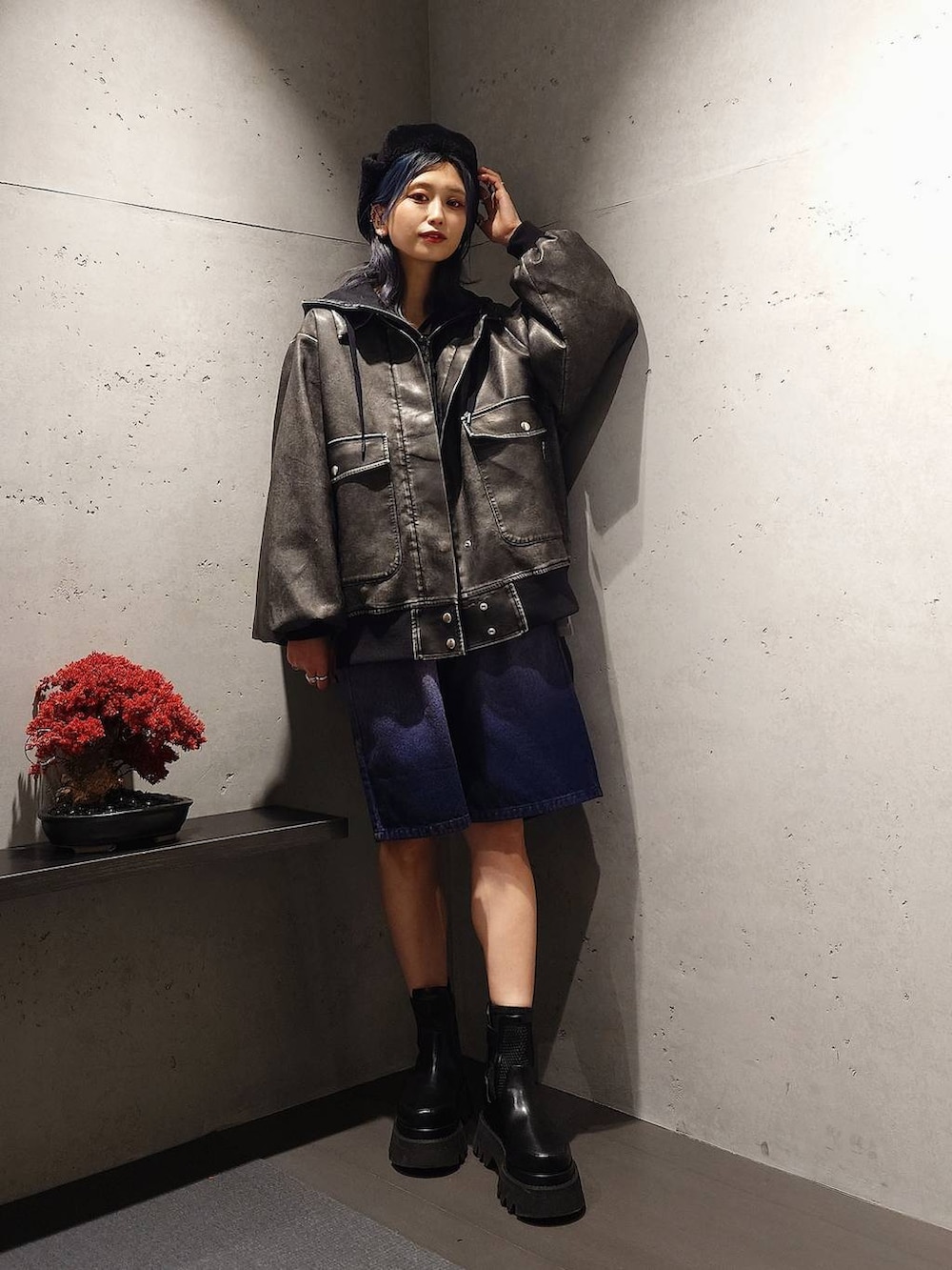 ブラック系のパーカー、パープル系のデニムパンツ、ブラック系のブーツを着用したレディースの冬コーディネートの2枚目の写真