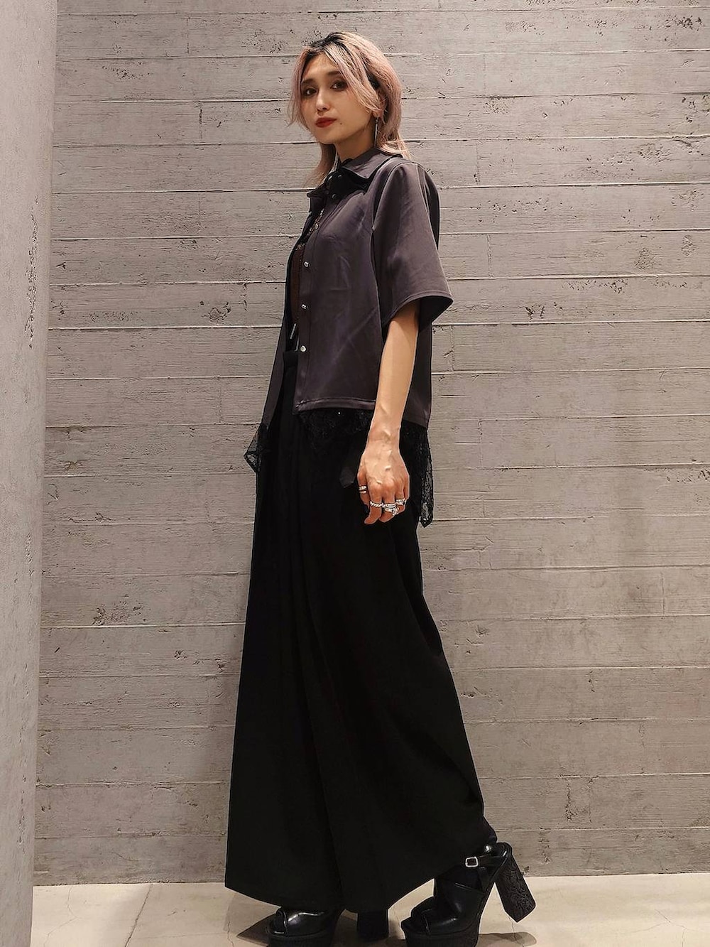 ブラック系のスラックス、ブラック系のサンダル、オレンジ系のTシャツ/カットソーを着用したレディースの夏コーディネートの2枚目の写真