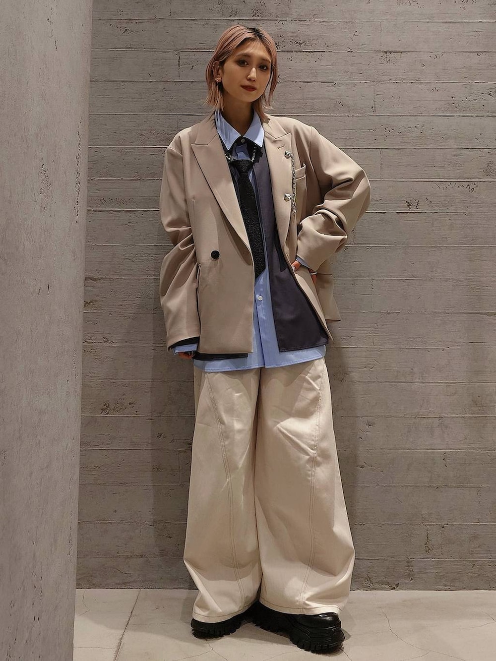 ブラック系のネクタイ、ブラック系のスニーカー、ベージュ系のテーラードジャケットを着用したレディースの冬コーディネートの2枚目の写真