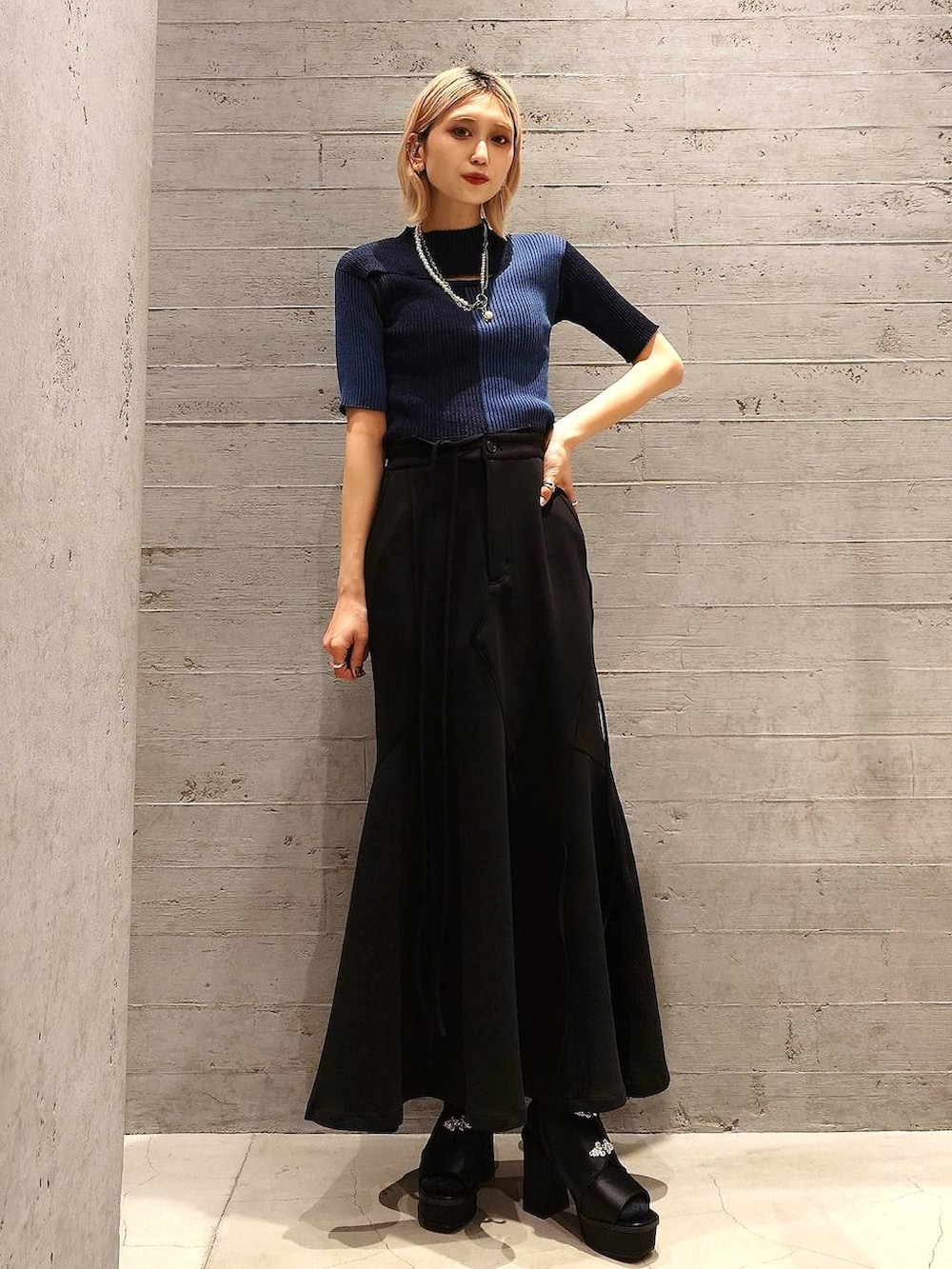 ブラック系のショルダーバッグ、ブラック系のテーラードジャケット、ブルー系のニット/セーターを着用したレディースの春コーディネートの2枚目の写真