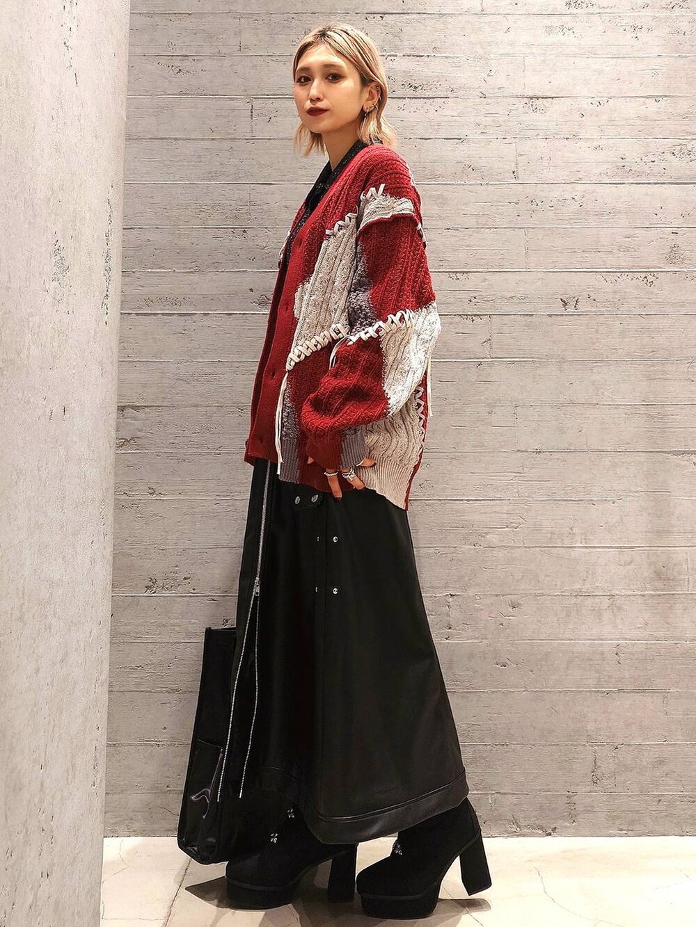 ブラック系のトートバッグ、ブラック系のカーディガン/ボレロ、レッド系のカーディガン/ボレロを着用したレディースの冬コーディネートの2枚目の写真