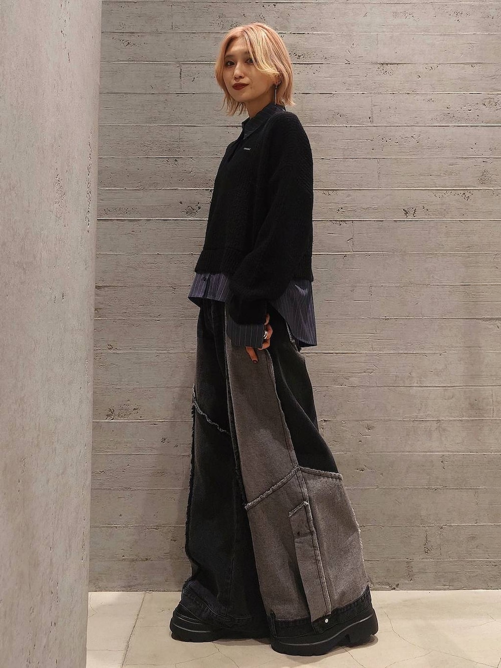 グレー系のダウンジャケット/コート、ブラック系のニット/セーター、ブラック系のデニムパンツを着用したレディースの冬コーディネートの2枚目の写真