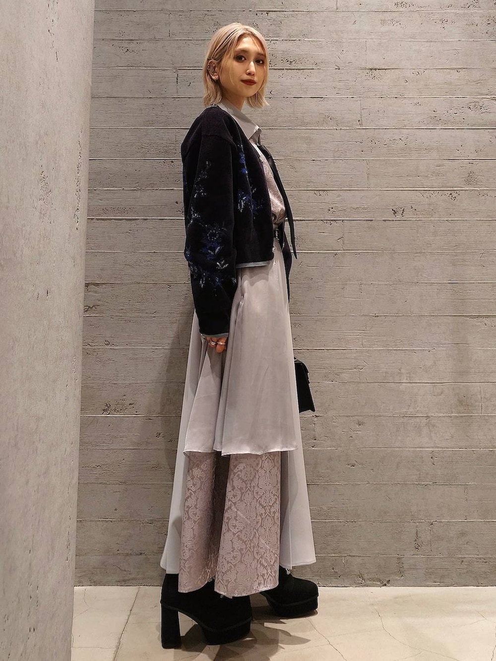 ブラック系のネクタイ、ブラック系のブーツ、ブラック系のハンドバッグを着用したレディースの冬コーディネートの3枚目の写真