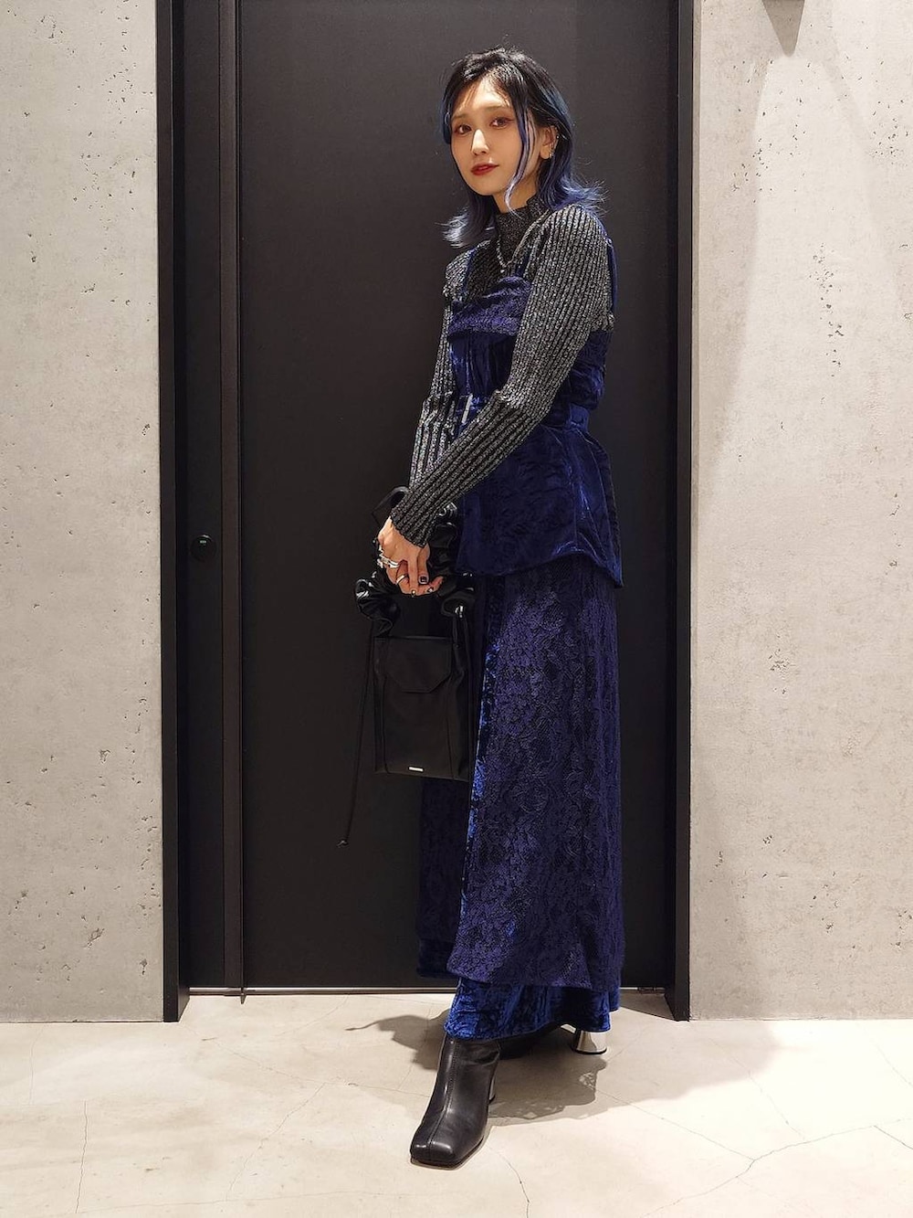 ブラック系のニット/セーター、ブラック系のブーツ、ブルー系のベストを着用したレディースの秋コーディネートの2枚目の写真