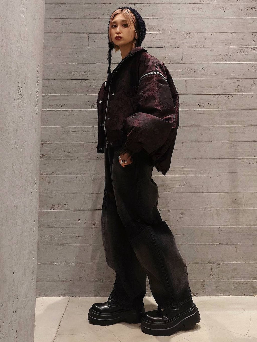 オレンジ系のブルゾン、ブラック系のブーツ、ブラック系のデニムパンツを着用したレディースの冬コーディネートの2枚目の写真