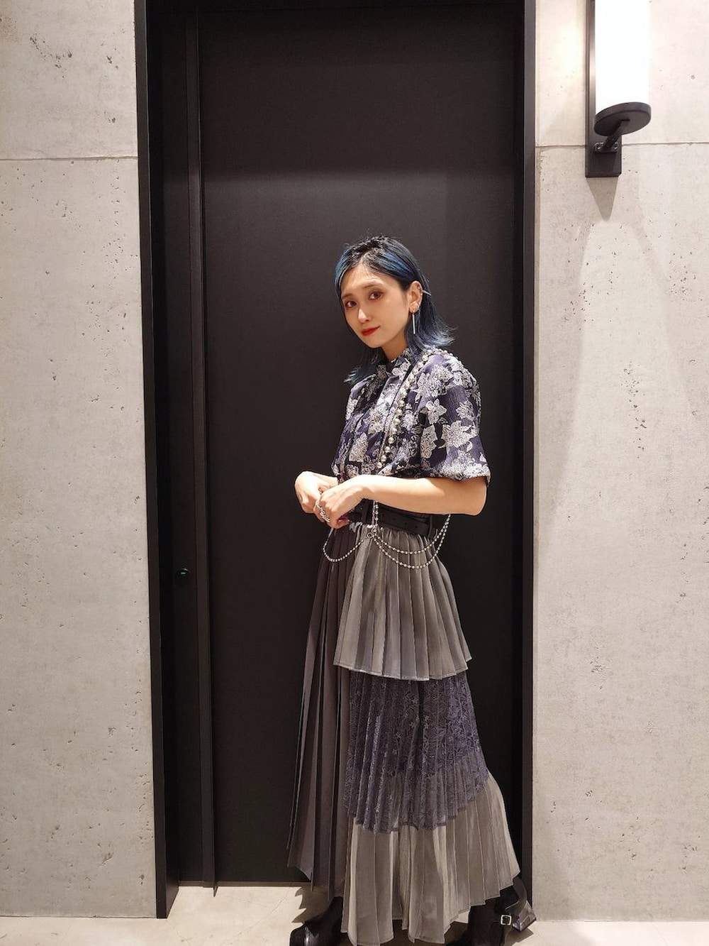 ブルー系のシャツ/ブラウス、ブラック系のサンダル、グレー系のスカートを着用したレディースの春コーディネートの2枚目の写真