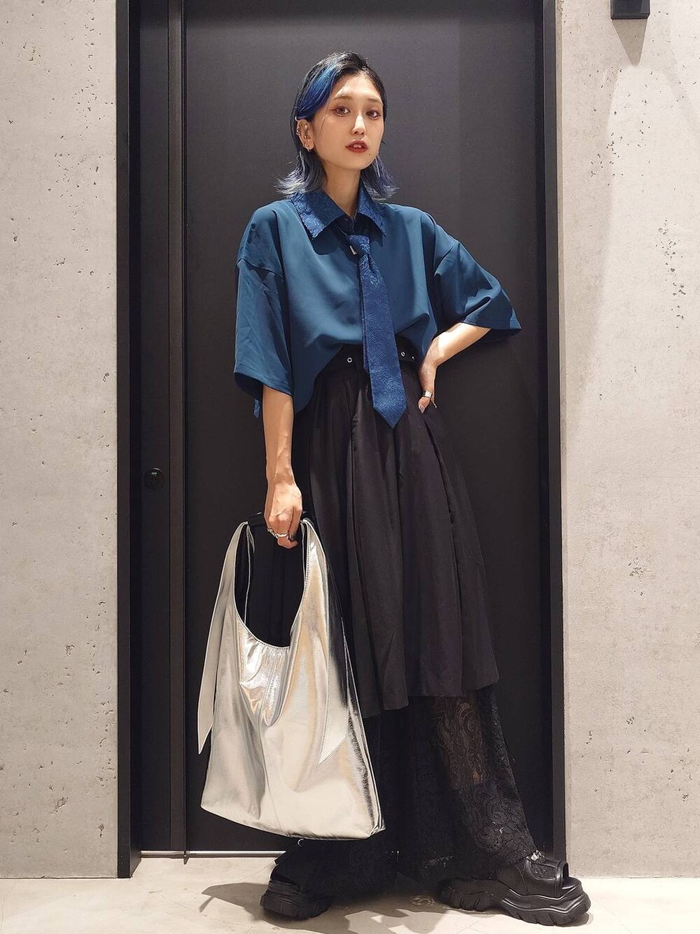 ブラック系のその他パンツ、ブルー系のシャツ/ブラウス、シルバー系のトートバッグを着用したレディースの夏コーディネートの2枚目の写真