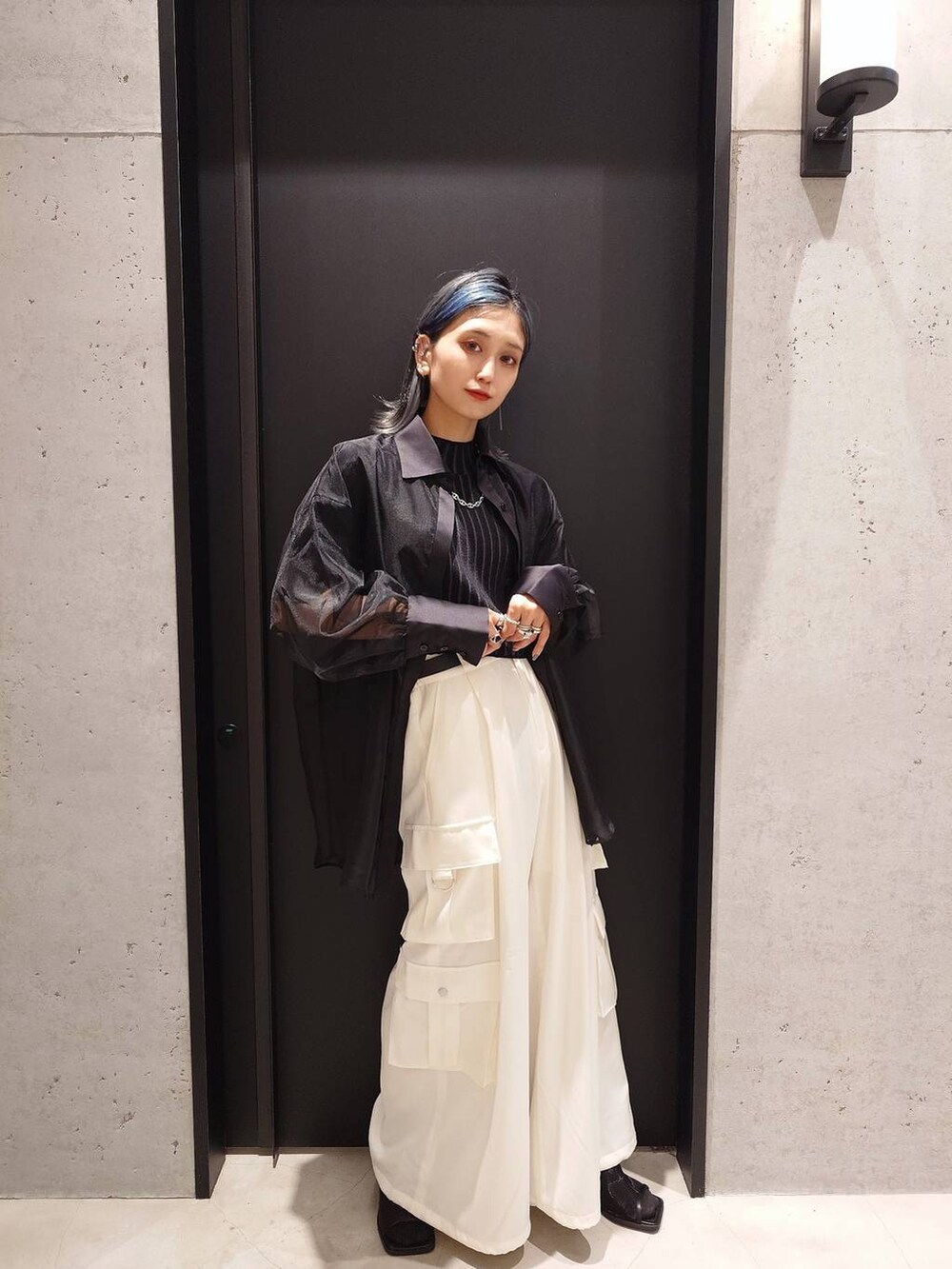 ブラック系のサンダル、ホワイト系のカーゴパンツ、ブラック系のニット/セーターを着用したレディースの春コーディネートの2枚目の写真