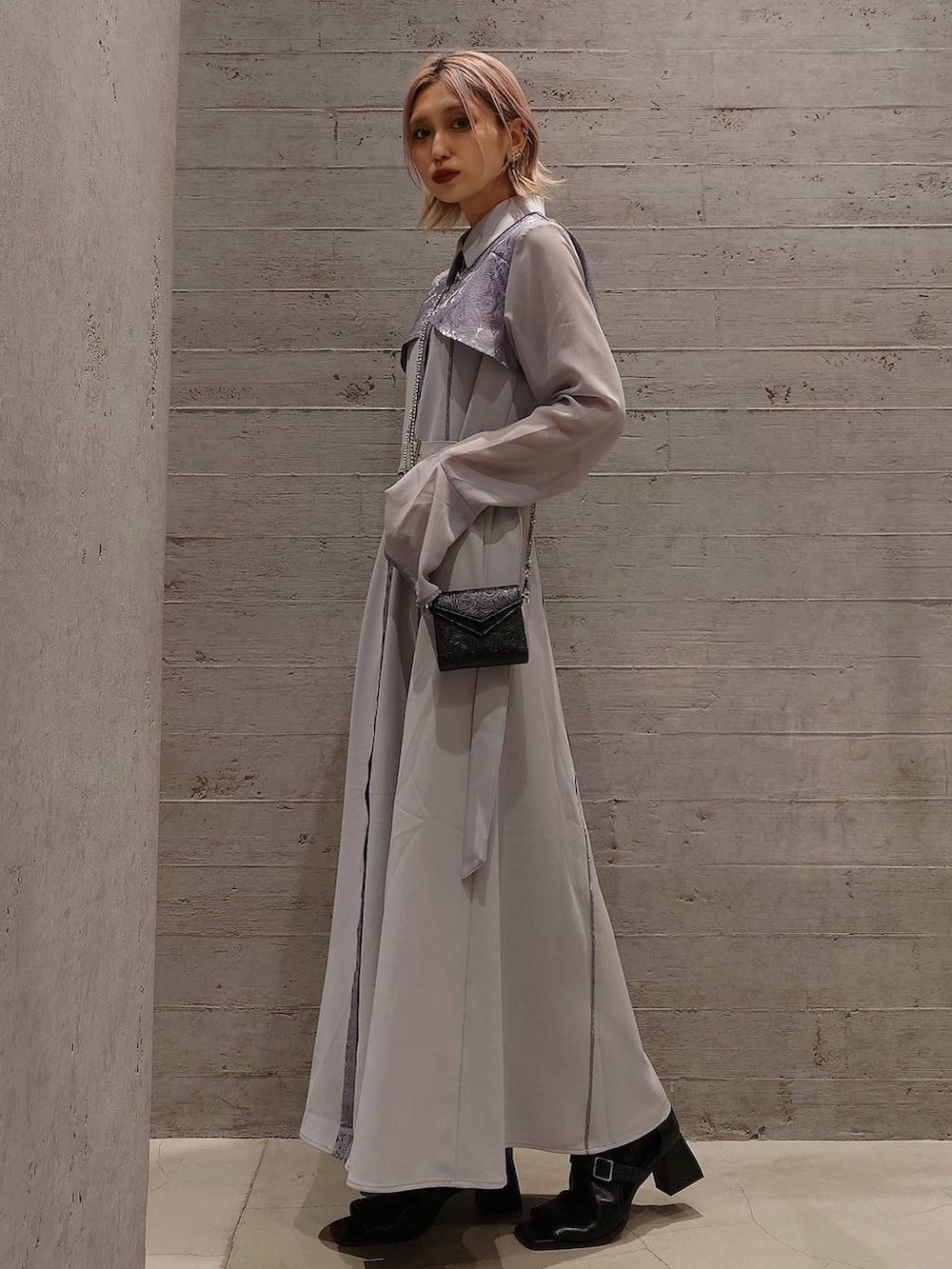 ブラック系のサンダル、グレー系のワンピース、ブラック系の財布を着用したレディースの春コーディネートの2枚目の写真