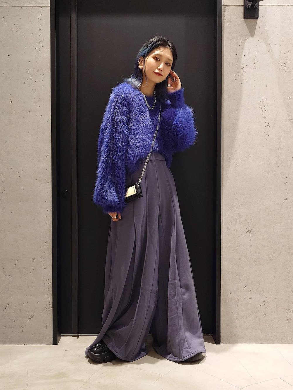 ブルー系のニット/セーター、ブラック系のスニーカー、ブルー系のスウェットパンツを着用したレディースの秋コーディネートの2枚目の写真