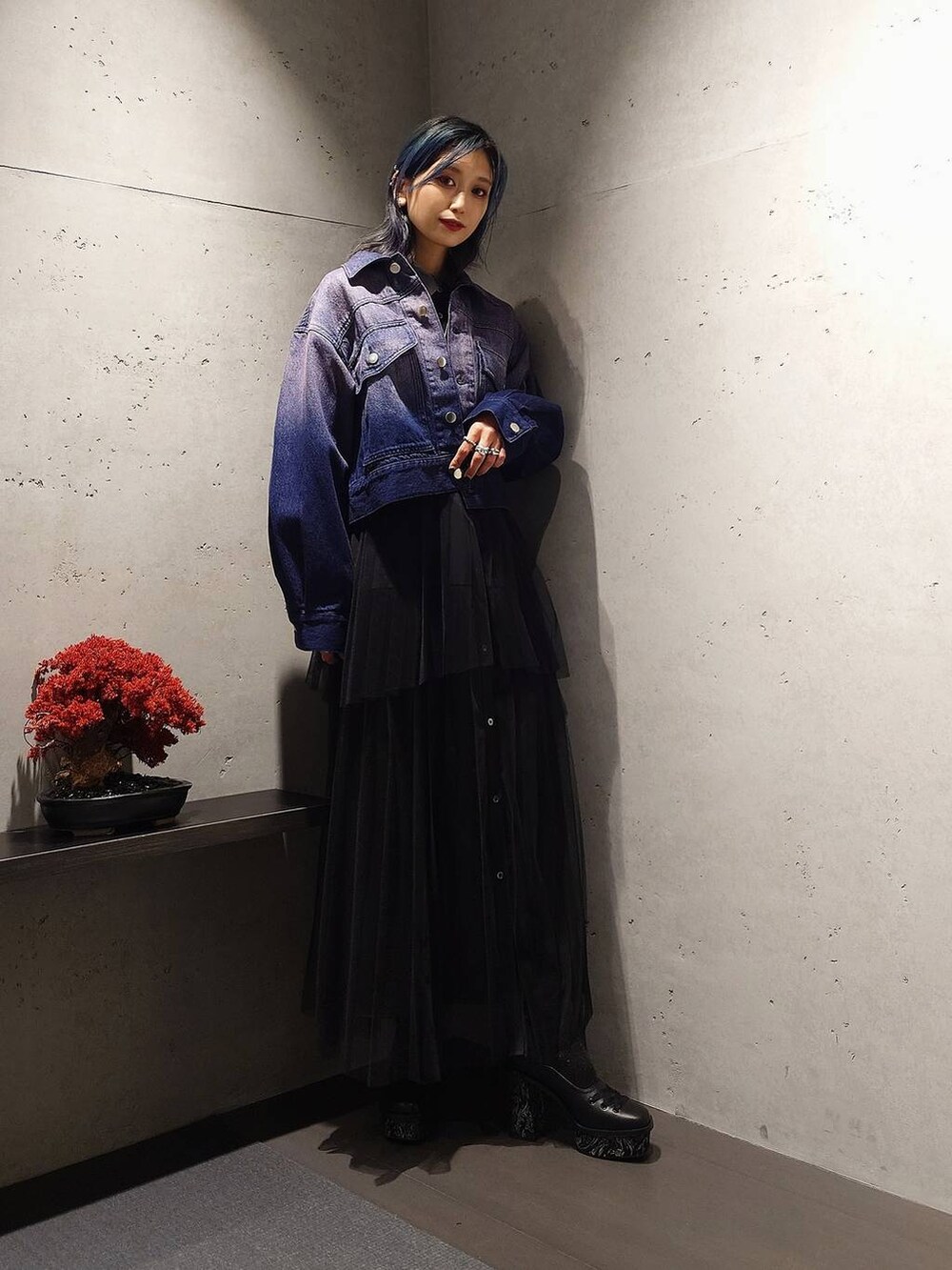 ブラック系のパンプス、パープル系のデニムジャケット、ブラック系のワンピースを着用したレディースの冬コーディネートの2枚目の写真