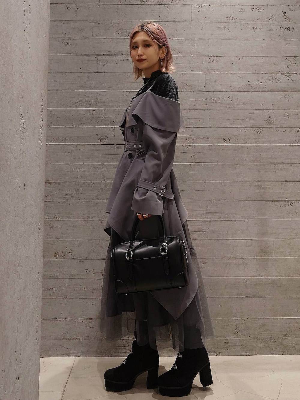 ブラック系のボストンバッグ、ブラック系のブーツ、ブラック系のTシャツ/カットソーを着用したレディースの冬コーディネートの2枚目の写真