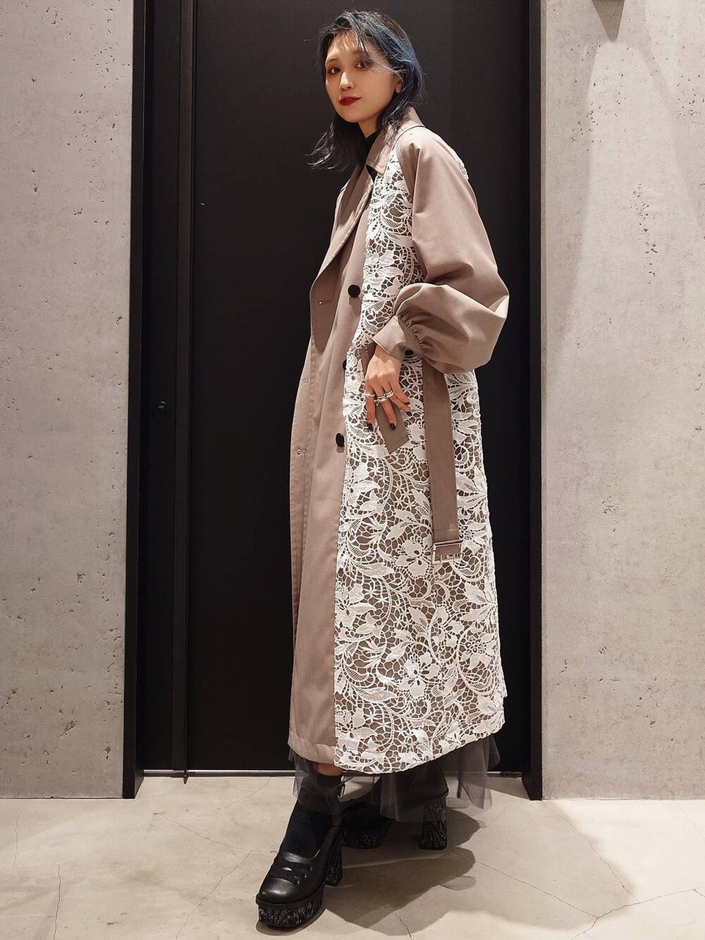 ブラック系のニット/セーター、ブラック系のショルダーバッグ、ベージュ系のトレンチコートを着用したレディースの冬コーディネートの3枚目の写真