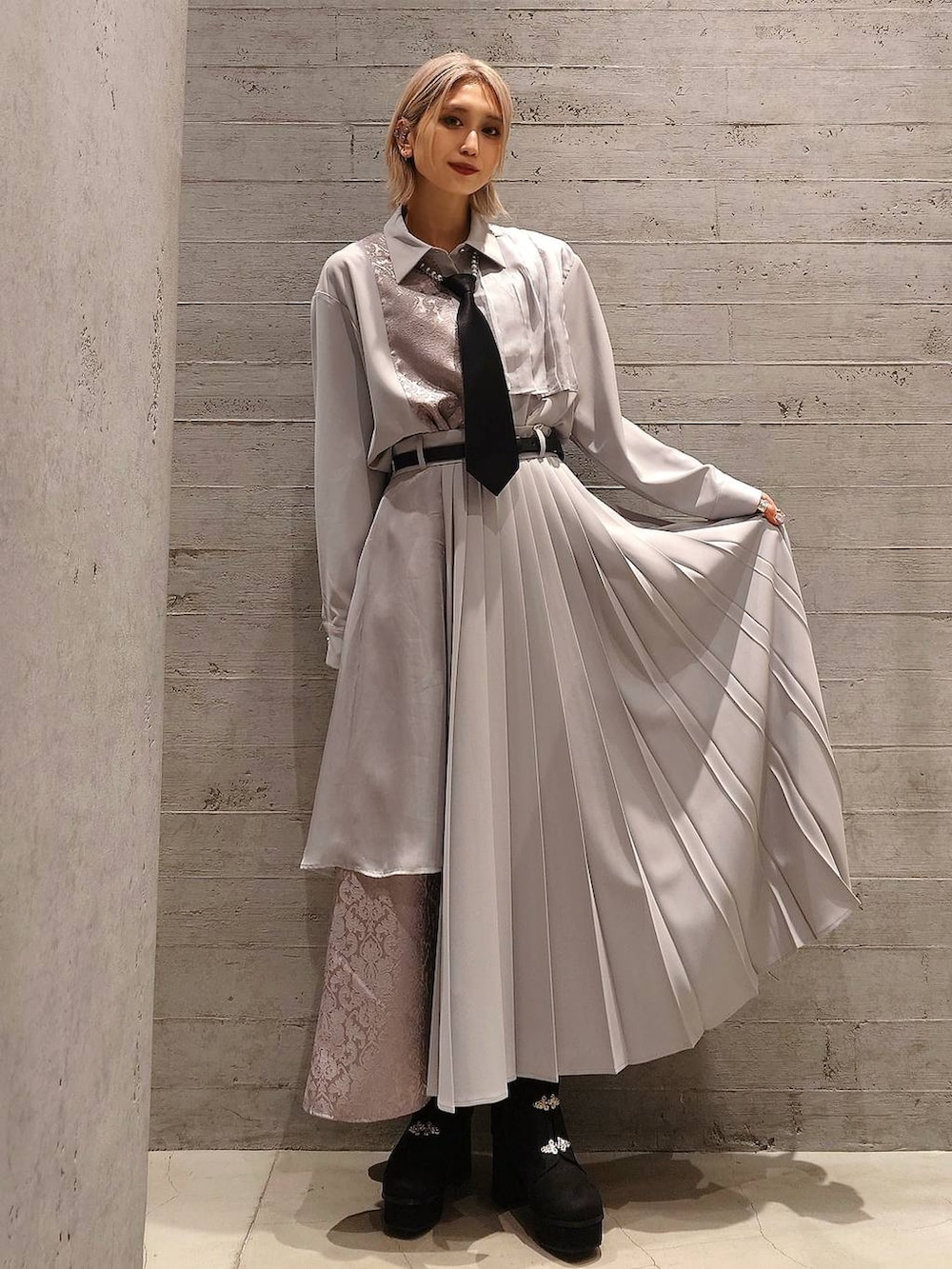 ブラック系のネクタイ、ブラック系のブーツ、ブラック系のハンドバッグを着用したレディースの冬コーディネートの2枚目の写真