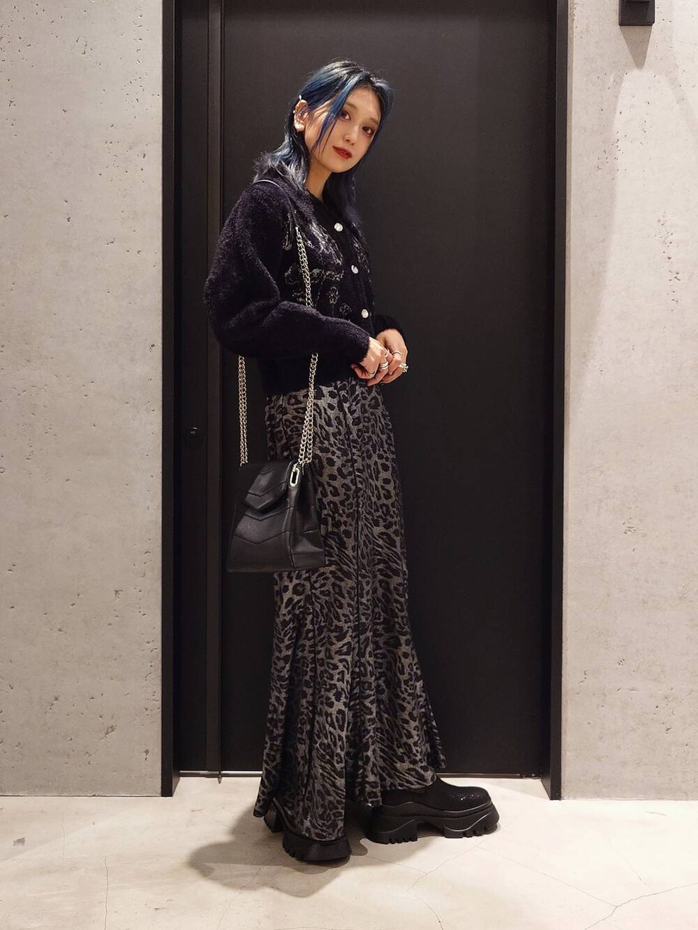 グレー系のトレンチコート、ブラック系のブーツ、ブラック系のショルダーバッグを着用したレディースの冬コーディネートの4枚目の写真