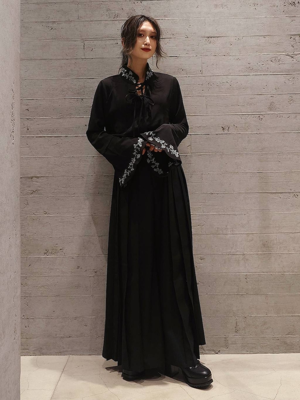 ブラック系のショルダーバッグ、ブラック系のシャツ/ブラウス、ブラック系のブーツを着用したレディースの秋コーディネートの2枚目の写真