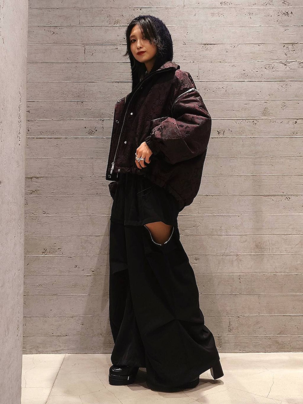 パープル系のニット/セーター、レッド系のブルゾン、ブラック系のカーゴパンツを着用したレディースの秋コーディネートの2枚目の写真