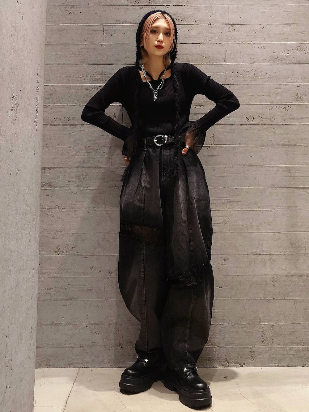 オレンジ系のブルゾン、ブラック系のブーツ、ブラック系のデニムパンツを着用したレディースの冬コーディネートの3枚目の写真