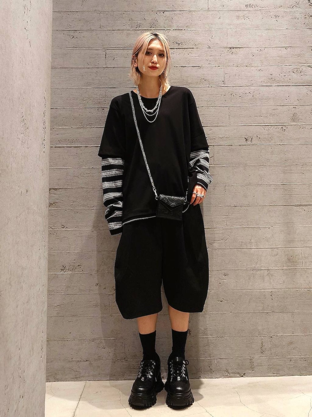 ブラック系のスニーカー、ブラック系のテーラードジャケット、ブラック系のスラックスを着用したレディースの春コーディネートの2枚目の写真