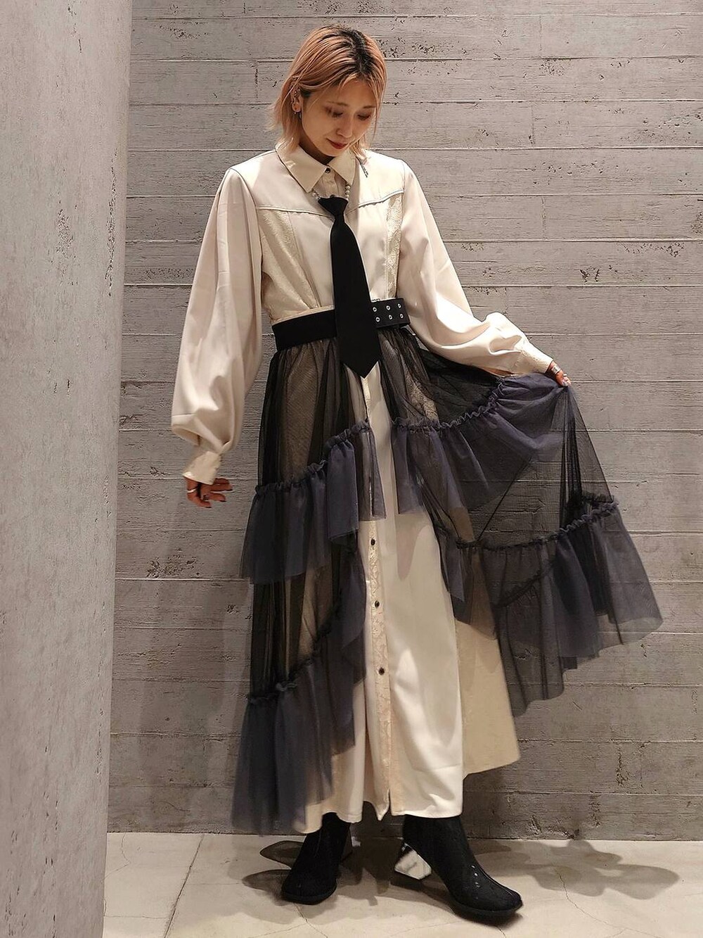 ブラック系のネクタイ、ブラック系のブーツ、ブラック系のスカートを着用したレディースの冬コーディネートの2枚目の写真