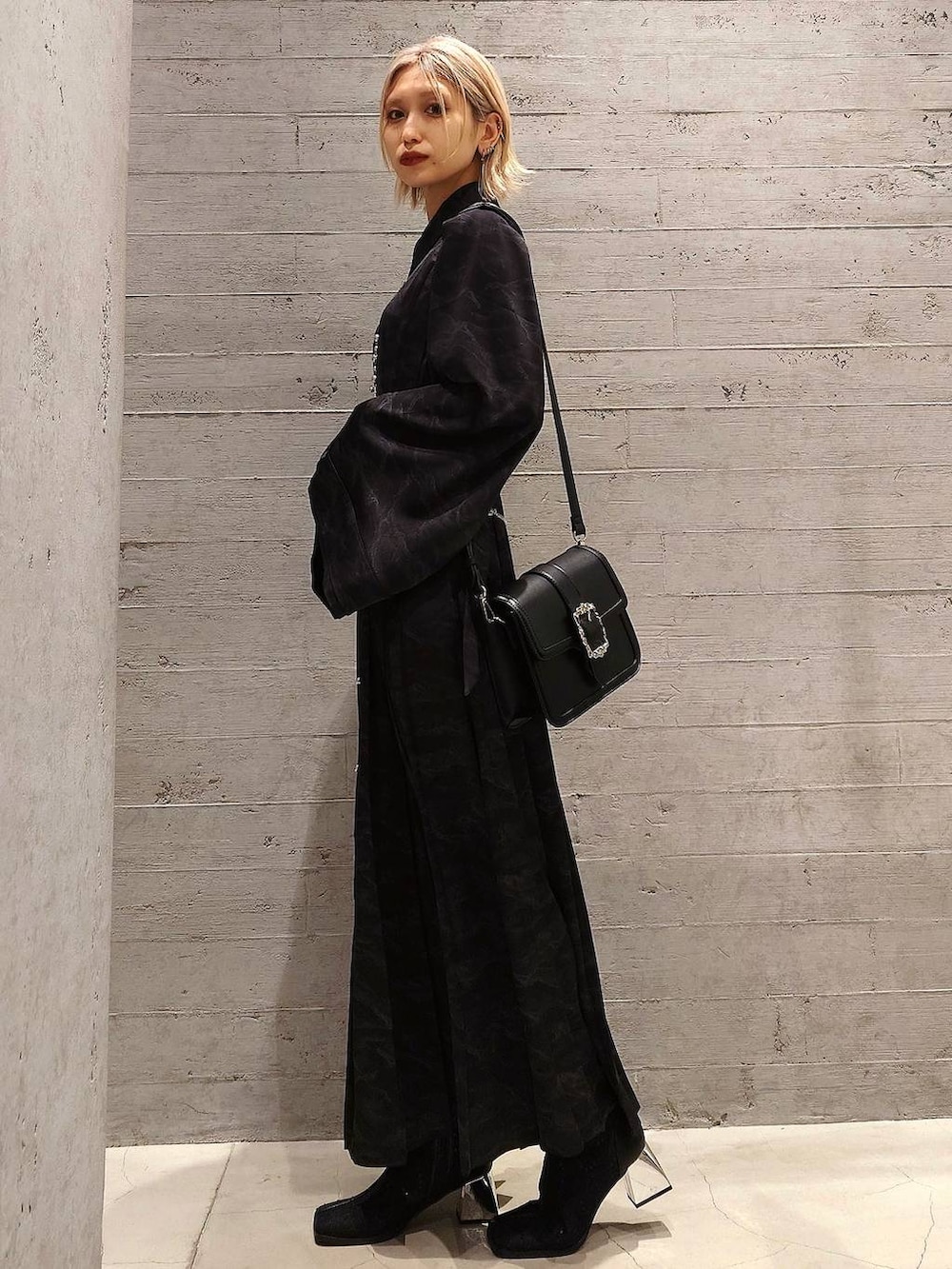 ブラック系のショルダーバッグ、ブラック系のブーツ、ブラック系のシャツワンピースを着用したレディースの冬コーディネートの2枚目の写真