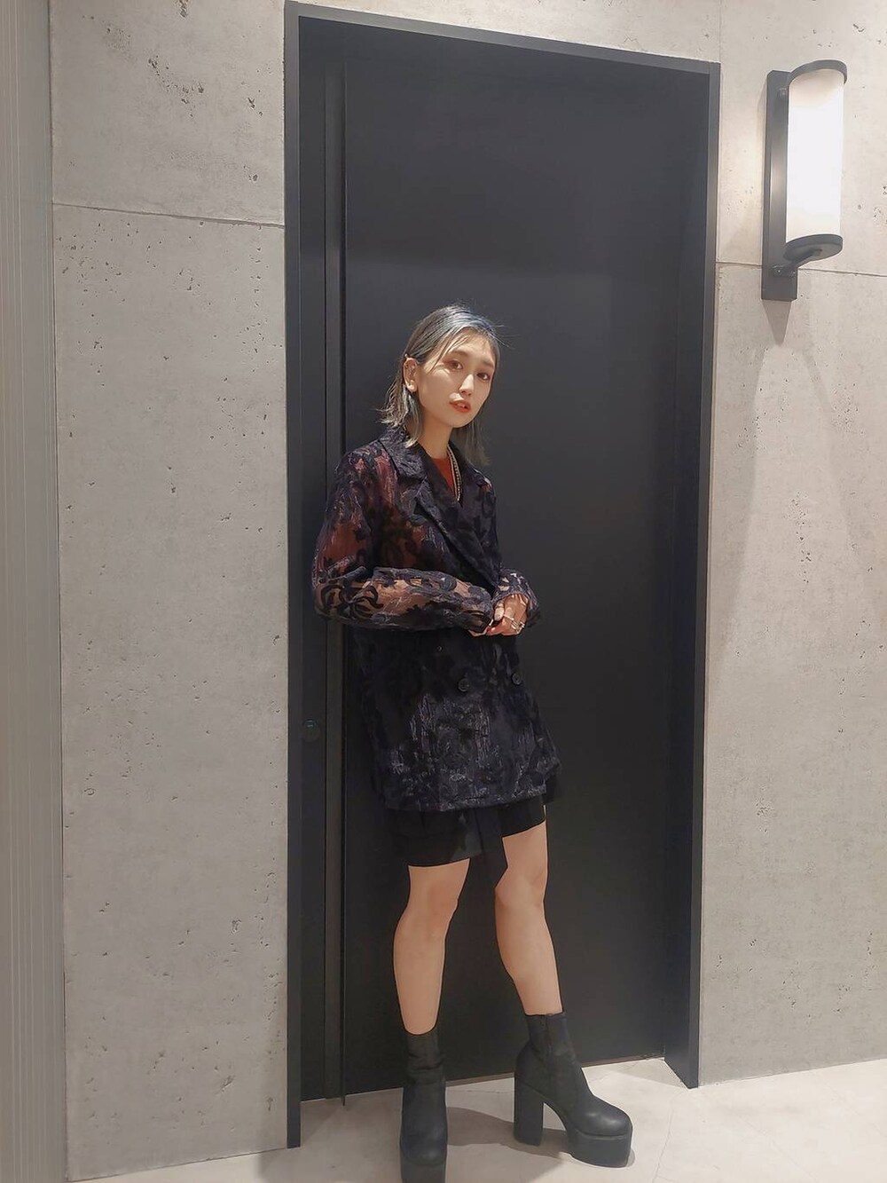 ブラック系のその他パンツ、ブラック系のショルダーバッグ、オレンジ系のニット/セーターを着用したレディースの春コーディネートの3枚目の写真