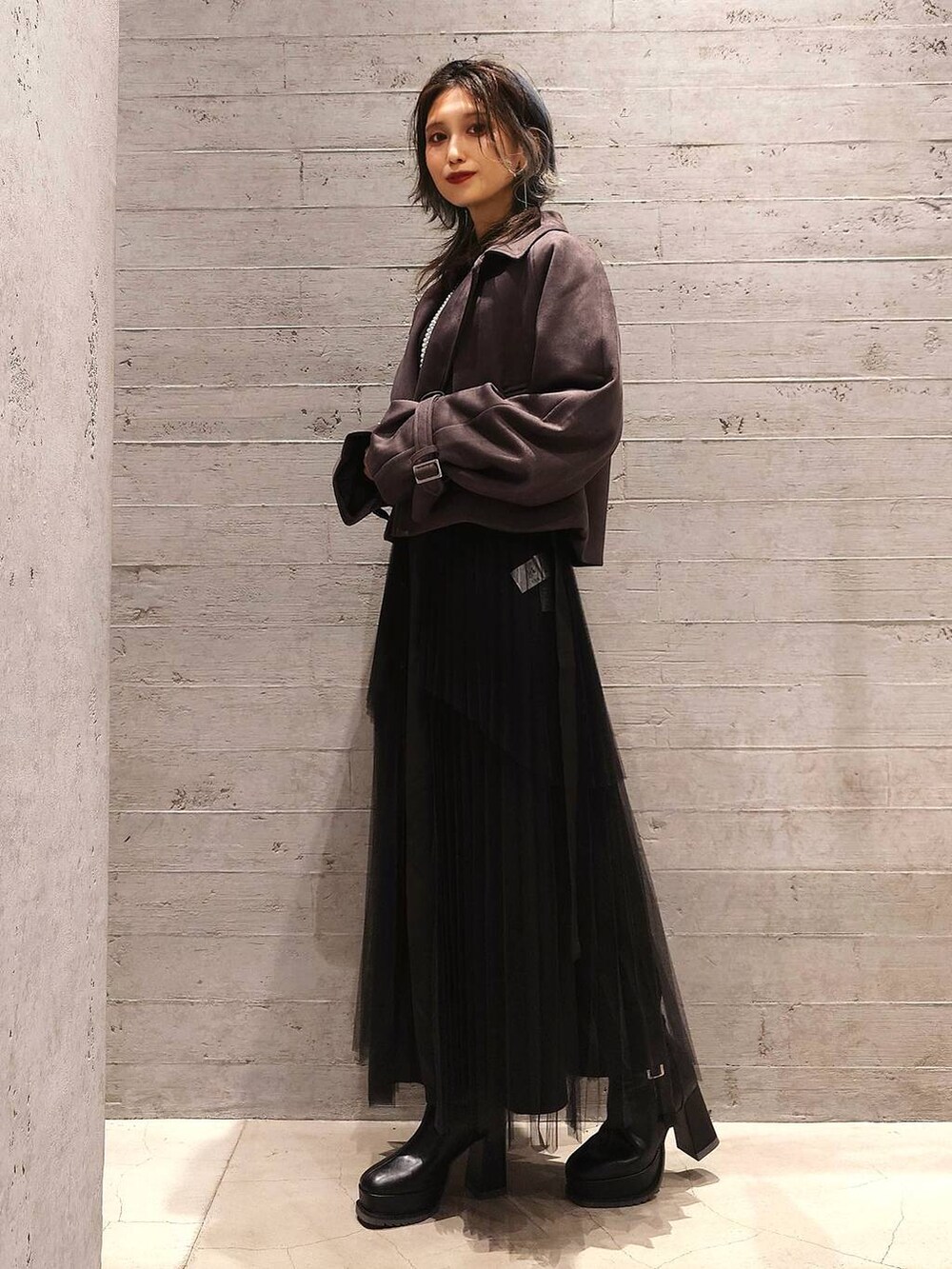 ブラック系のブーツ、グレー系のトレンチコート、ブラック系のワンピースを着用したレディースの秋コーディネートの3枚目の写真