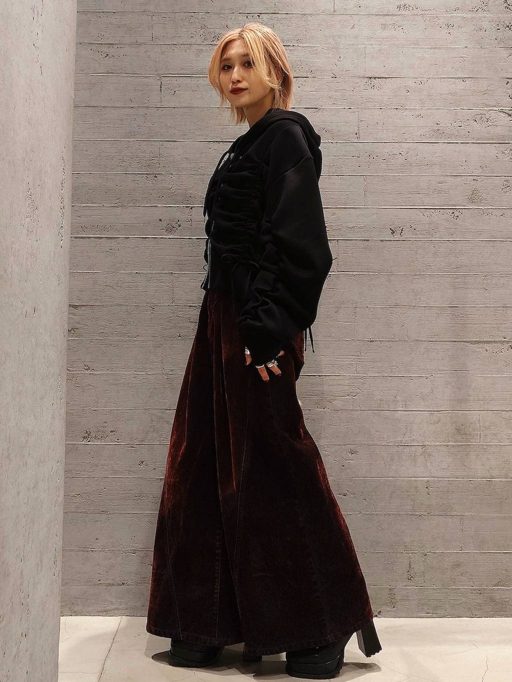 ブラック系のボストンバッグ、ブラック系のブーツ、レッド系のデニムパンツを着用したレディースの冬コーディネートの2枚目の写真