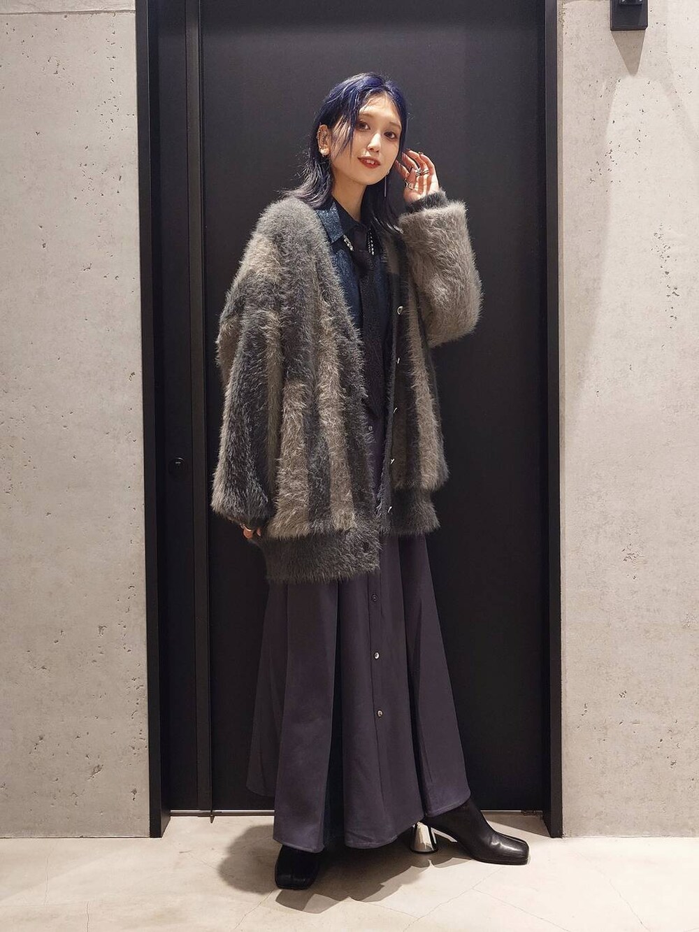 ブラック系のネクタイ、ブラック系のブーツ、グレー系のカーディガン/ボレロを着用したレディースの秋コーディネートの2枚目の写真