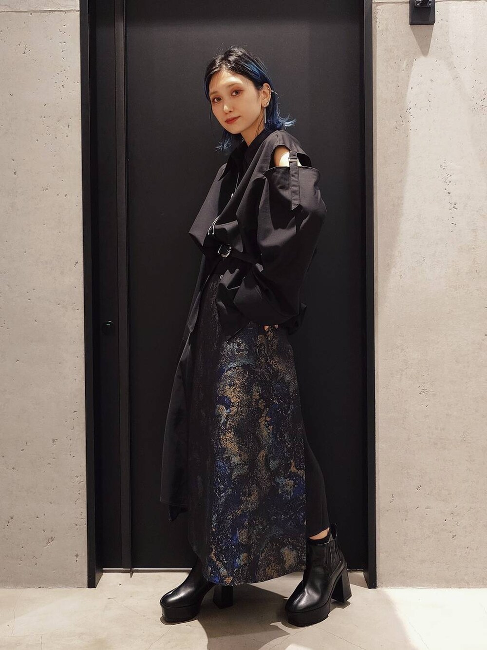 ブラック系のシャツ/ブラウス、ブラック系のブーツ、ブルー系のスカートを着用したレディースの夏コーディネートの2枚目の写真