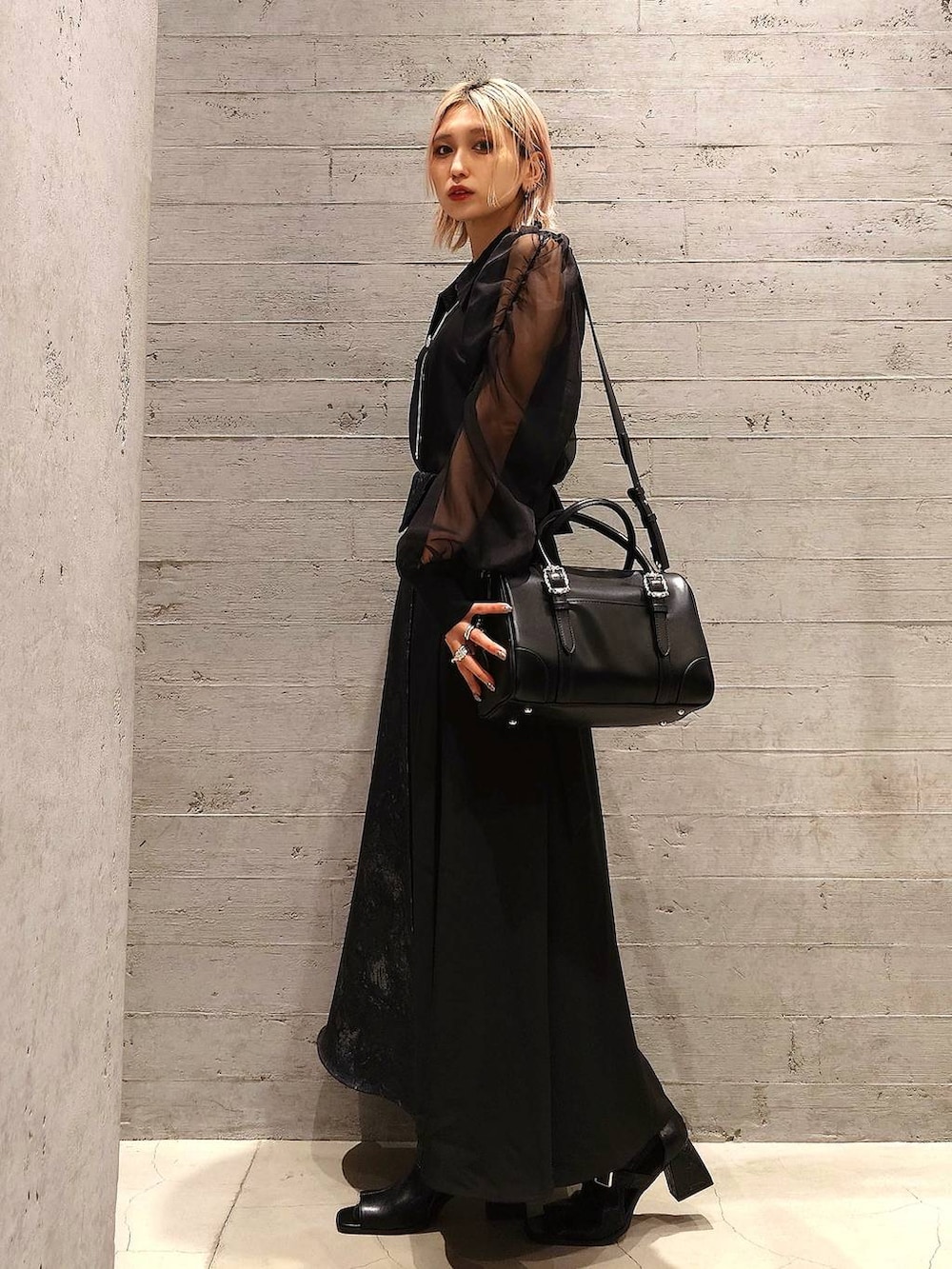 ブラック系のタンクトップ、ブラック系のボストンバッグ、ブラック系のサンダルを着用したレディースの春コーディネートの2枚目の写真