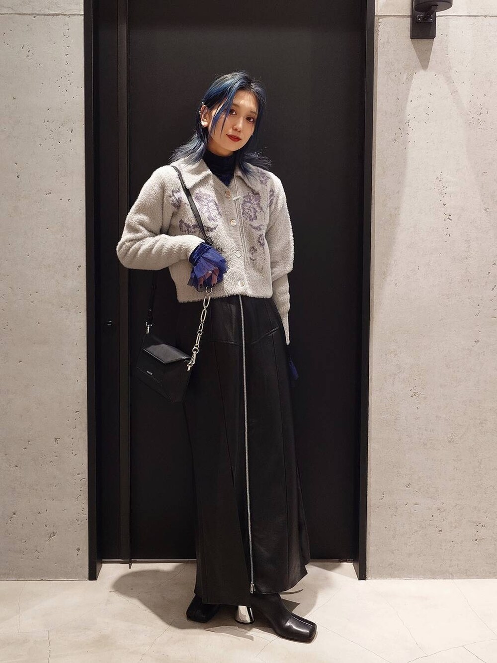 ブラック系のブーツ、ブルー系のTシャツ/カットソー、ベージュ系のブルゾンを着用したレディースの冬コーディネートの2枚目の写真