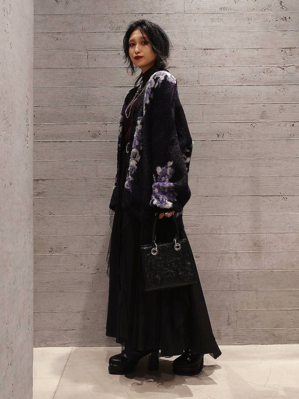 レッド系のニット/セーター、ブラック系のショルダーバッグ、ブラック系のカーディガン/ボレロを着用したレディースの秋コーディネートの2枚目の写真