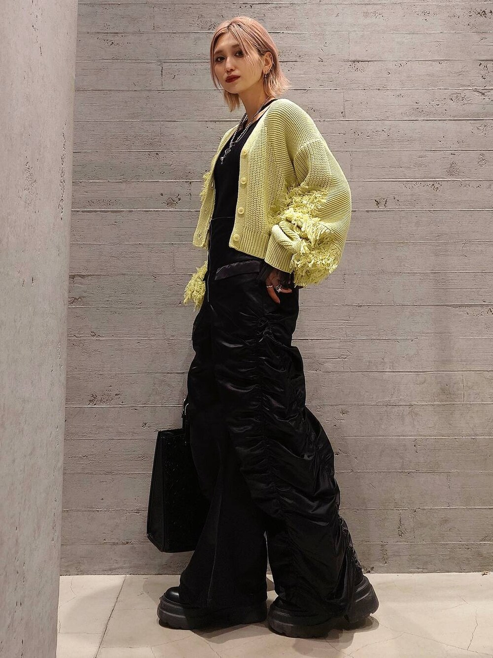 イエロー系のカーディガン/ボレロ、ブラック系のその他パンツ、ブラック系のトートバッグを着用したレディースの冬コーディネートの2枚目の写真
