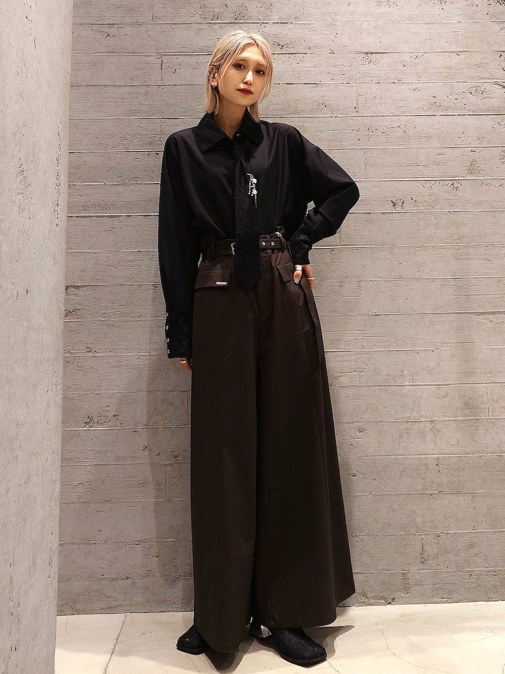 ブラック系のショルダーバッグ、ブラック系のシャツ/ブラウス、ブラック系のブーツを着用したレディースの冬コーディネートの2枚目の写真