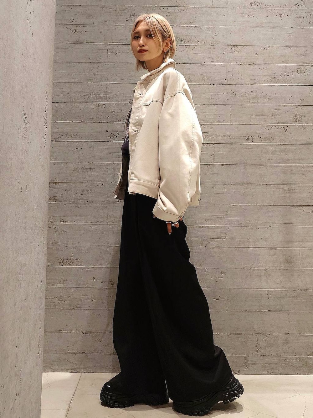 ブラック系のスニーカー、ホワイト系のデニムジャケット、グレー系のスウェットを着用したレディースの冬コーディネートの3枚目の写真