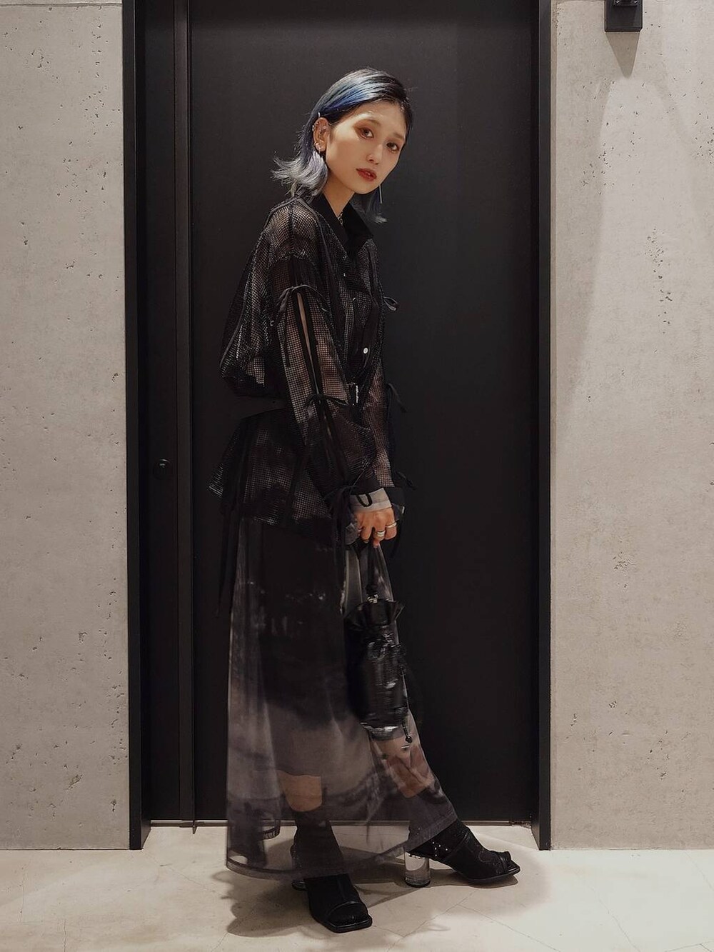 ブラック系のサンダル、ブラック系のシャツ/ブラウス、ブラック系のショルダーバッグを着用したレディースの夏コーディネートの2枚目の写真