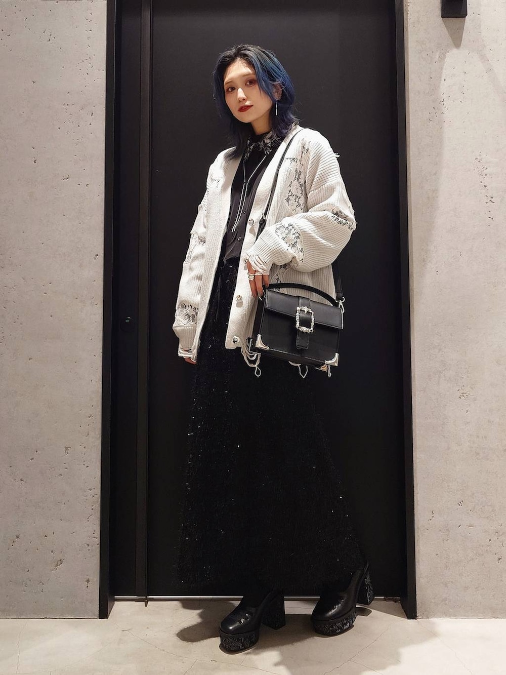 ブラック系のシャツ/ブラウス、ホワイト系のカーディガン/ボレロ、ブラック系のショルダーバッグを着用したレディースの冬コーディネートの2枚目の写真