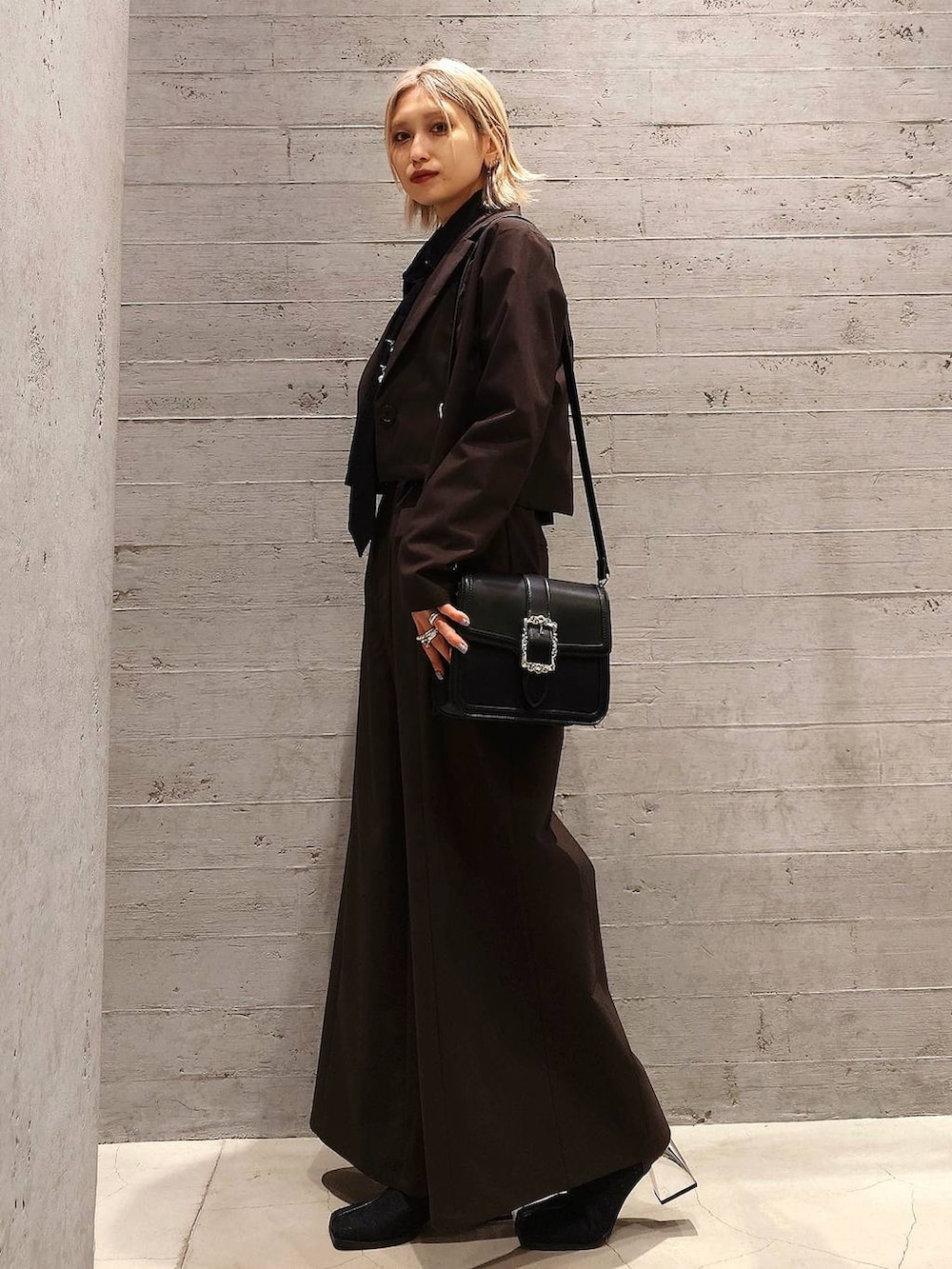 ブラック系のショルダーバッグ、ブラック系のシャツ/ブラウス、ブラック系のブーツを着用したレディースの冬コーディネートの3枚目の写真