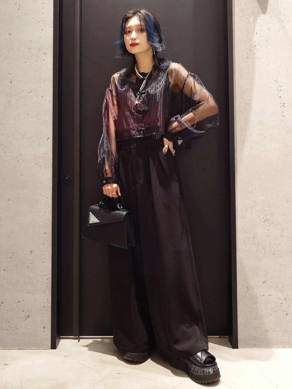 ブラック系のタンクトップ、ブラック系のその他パンツ、ブラック系のハンドバッグを着用したレディースの春コーディネートの2枚目の写真