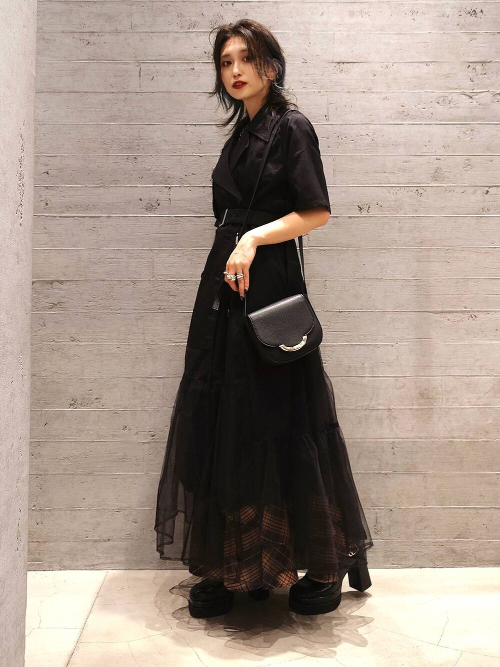 ブラック系のタンクトップ、オレンジ系のスカート、ブラック系のサンダルを着用したレディースの夏コーディネートの3枚目の写真