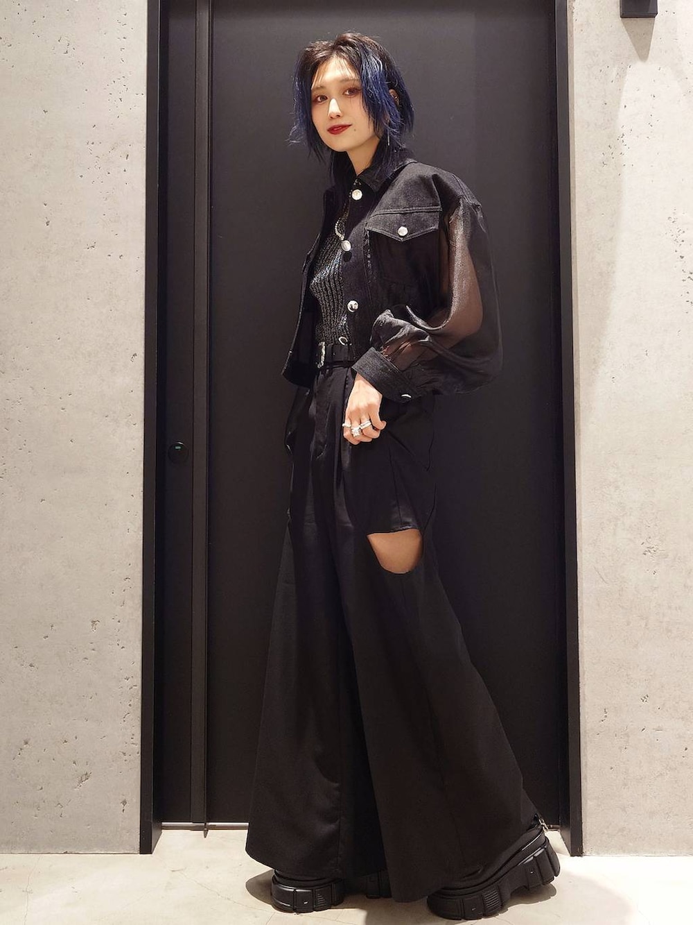 ブラック系のタンクトップ、ブラック系のブルゾン、ブラック系のサンダルを着用したレディースの春コーディネートの2枚目の写真