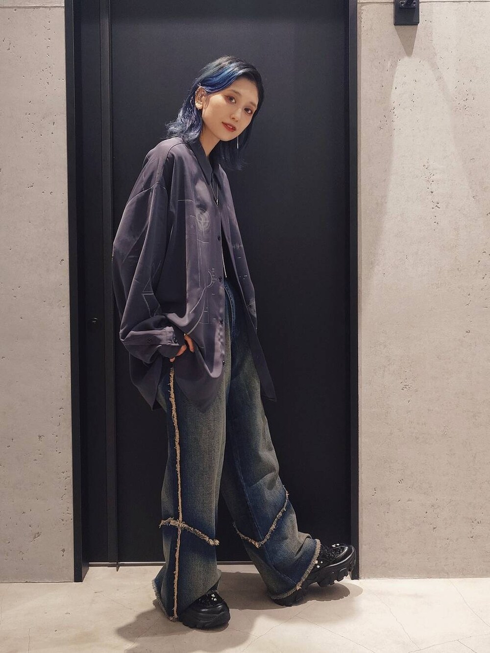 ブルー系のデニムパンツ、ブラック系のショルダーバッグ、ブラック系のスニーカーを着用したレディースの秋コーディネートの2枚目の写真