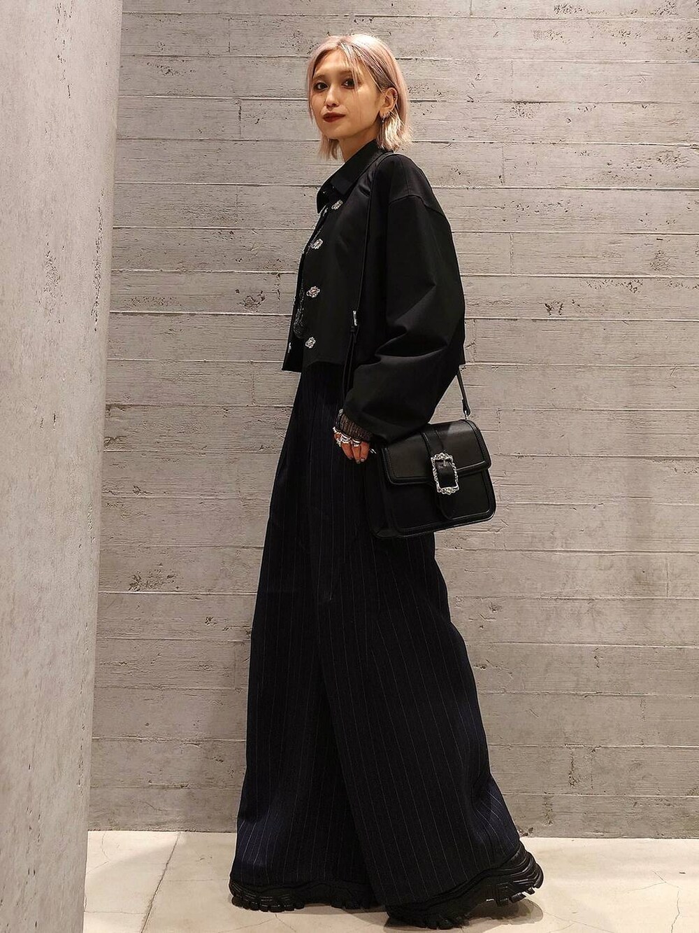 ブラック系のスニーカー、ブラック系のショルダーバッグ、ブラック系のTシャツ/カットソーを着用したレディースの冬コーディネートの2枚目の写真